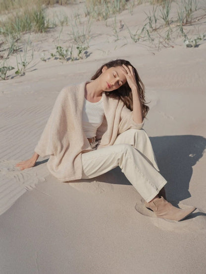 Woman wearing merino mohair wrap sitting on beach