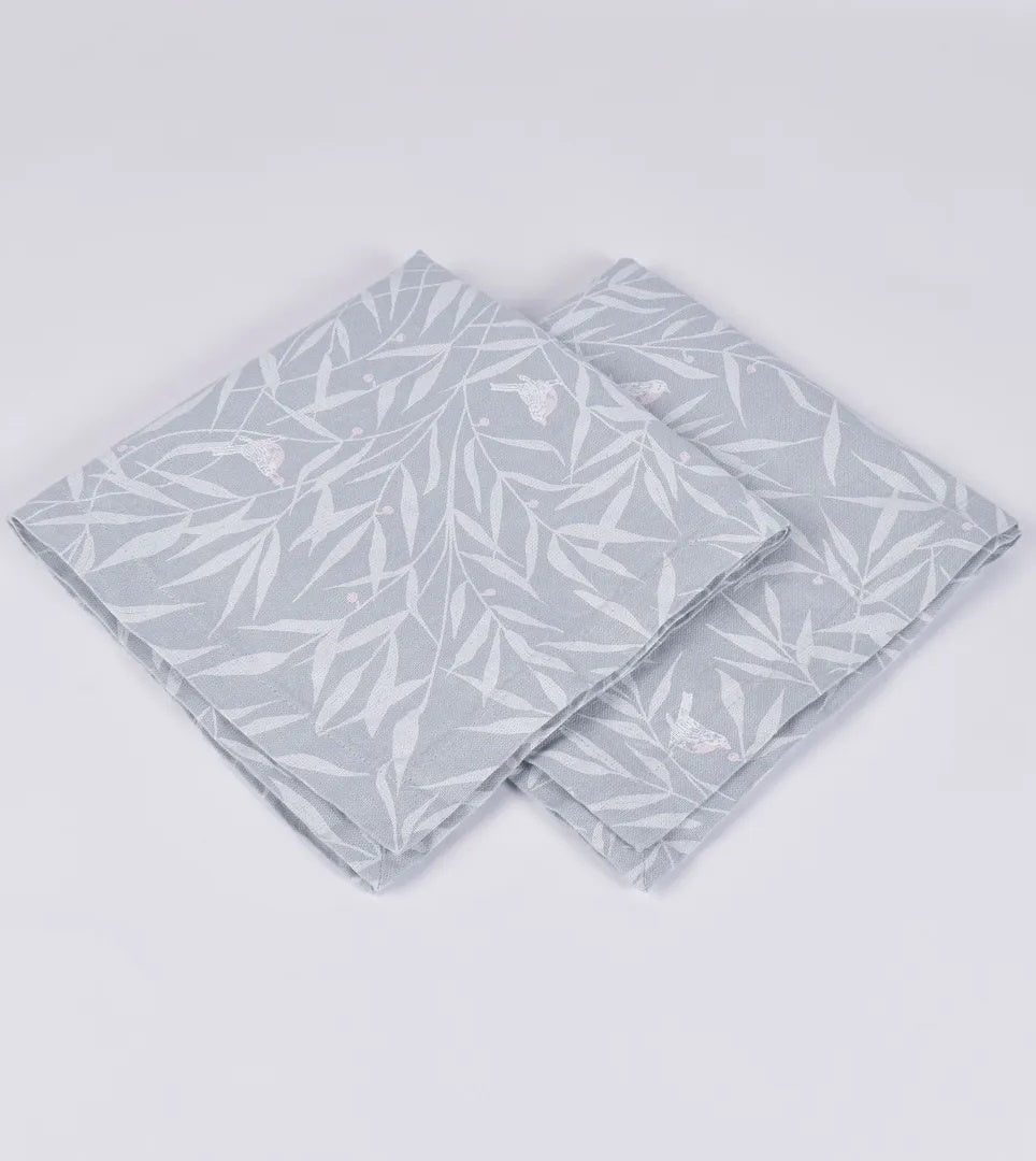 Set of four pale blue linen napkins with leaf design.
