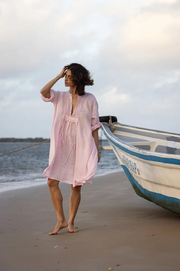 Woman wearing tunic dress in  pink linen with soft ruching.