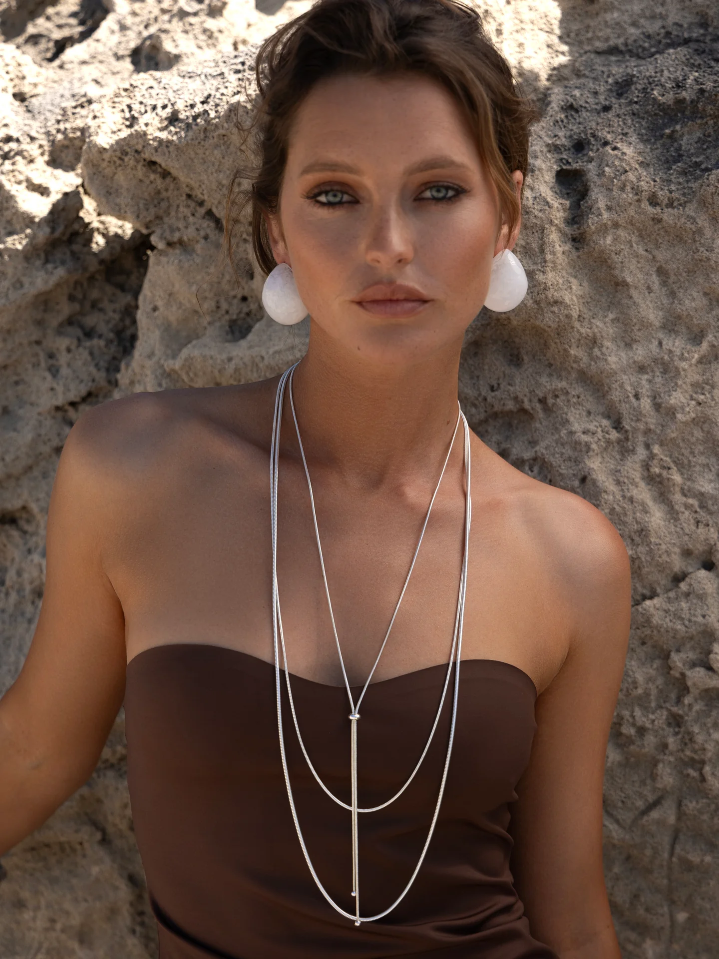 Woman wearing a three layer slide necklace in silver chain.