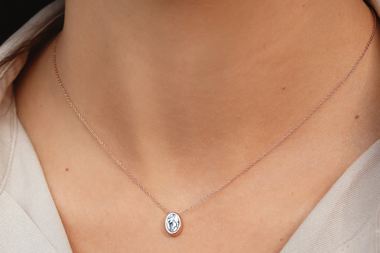 Woman wearing a crystal necklace with rose gold plating and delicate rose gold chain.