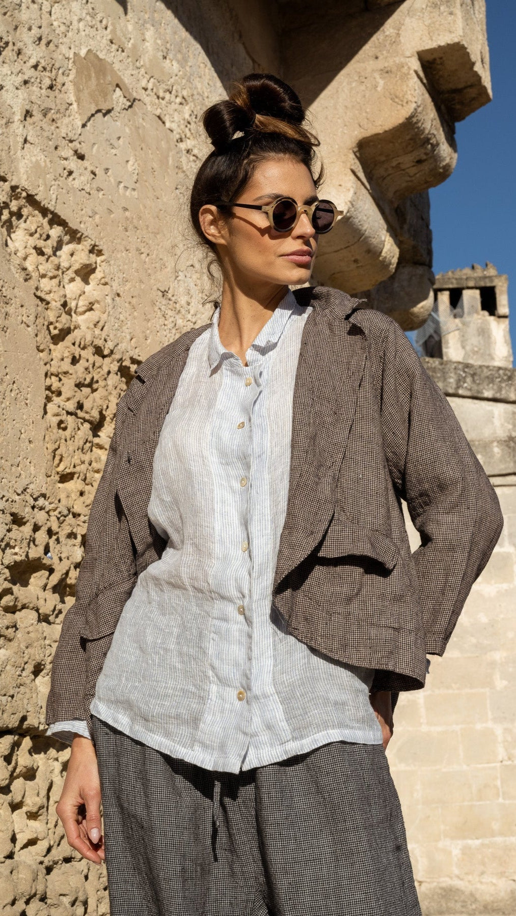 Woman wearing medium weight navy houndstooth jacket with pockets.