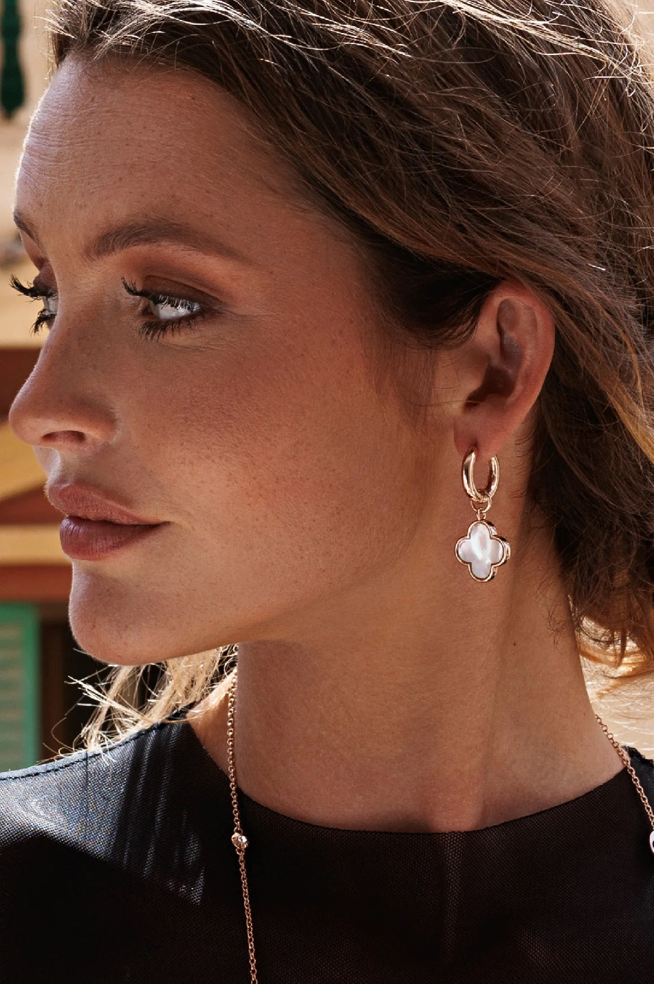 Model wearing flower shell earrings