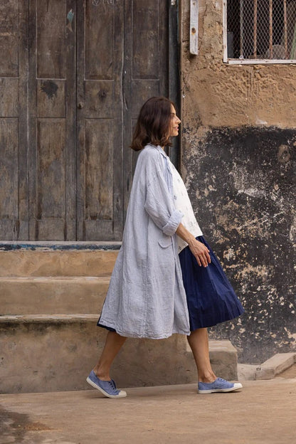 Woman walking in linen shirt and skirt, urban setting, stylish comfortable clothing