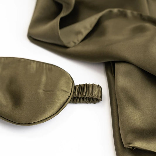 Olive green silk eye mask and matching silk fabric on white background