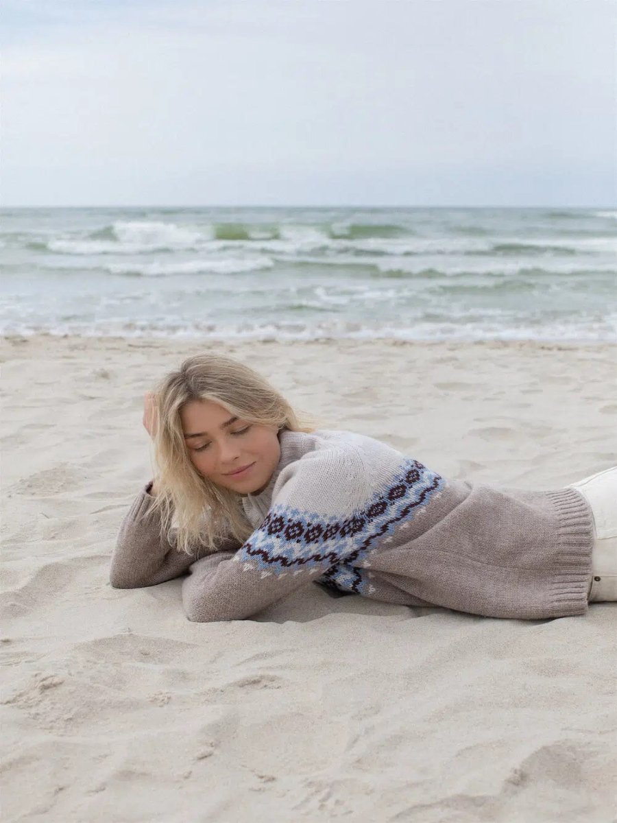 Model lying down wearing nordic sweater