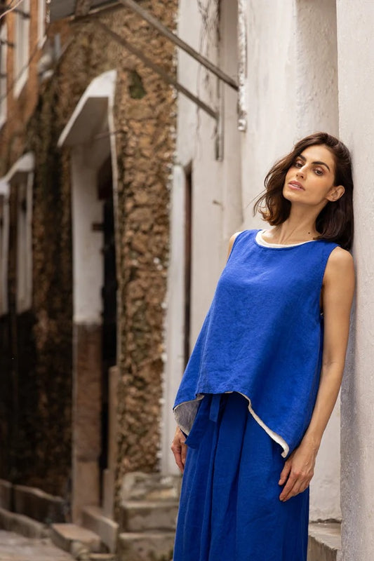 Woman wearing cobalt blue round neck linen sleeveless top with tapered sides.
