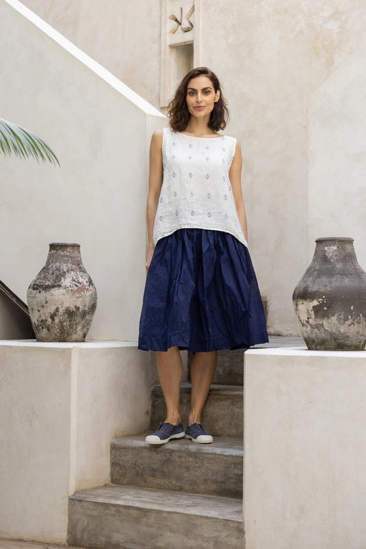 Woman wearing short cotton organdy tutu dress with white cotton bodice and indigo dress.