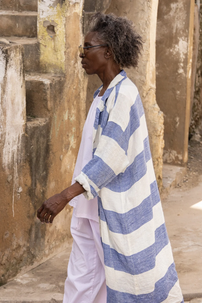Woman wearing blue and white striped linen shirt and white linen pants outdoors