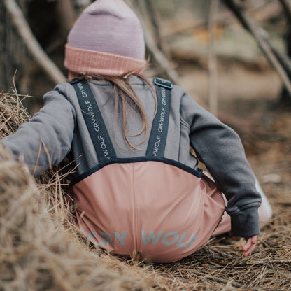 Kid wearing waterproof overalls pink back