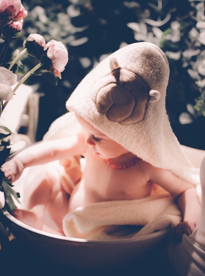 Baby wearing organic cotton towel with teddy hood
