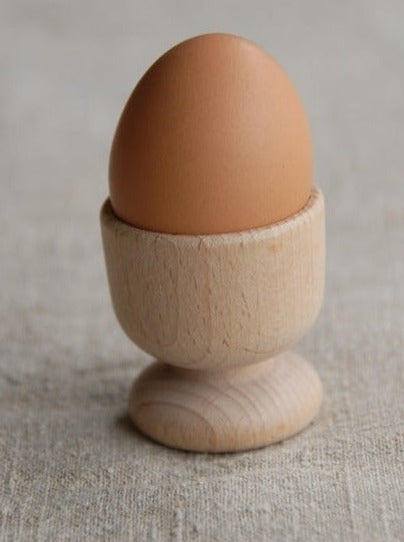 wooden egg cup with brown egg